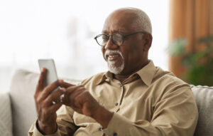 Senior man Scrolling information about his insurance options sent via email by his insurance agent