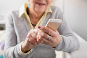 Senior woman holding smartphone looking at final expense insurance options