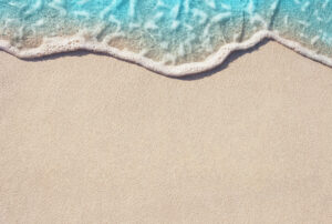 close up of beach with wave hitting the shore