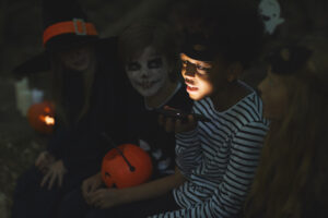 kid telling a ghost story at halloween get together